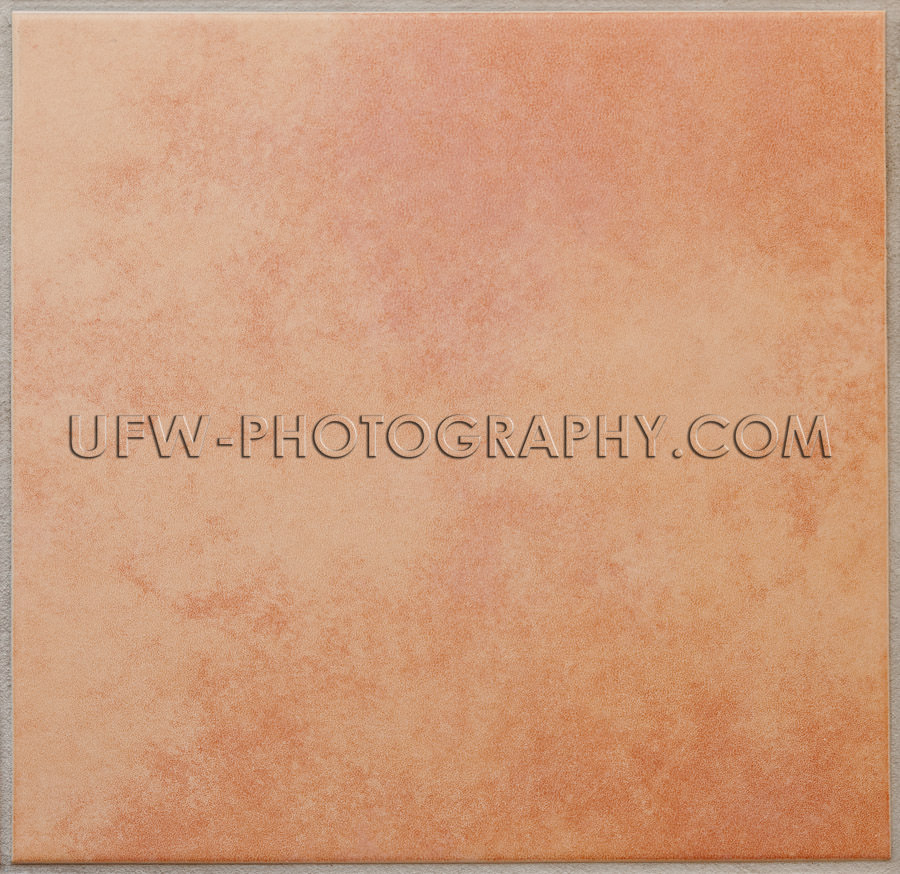 Single apricot colored ceramic tile textured full frame Stock Im