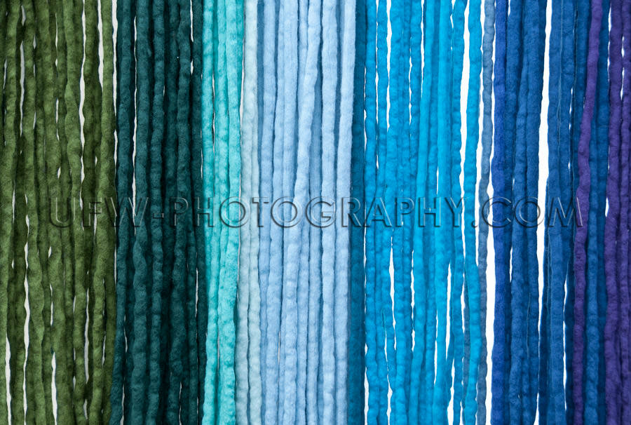 Hanging felt ribbons shades from green to blue background Stock 