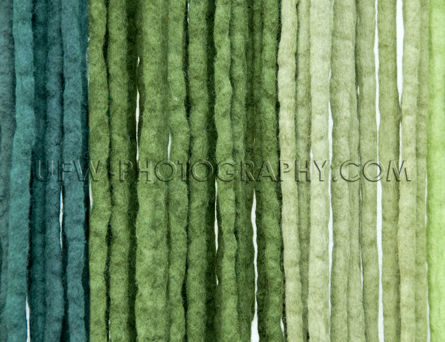 Felt ribbons blue green colored vertical strings background Stoc