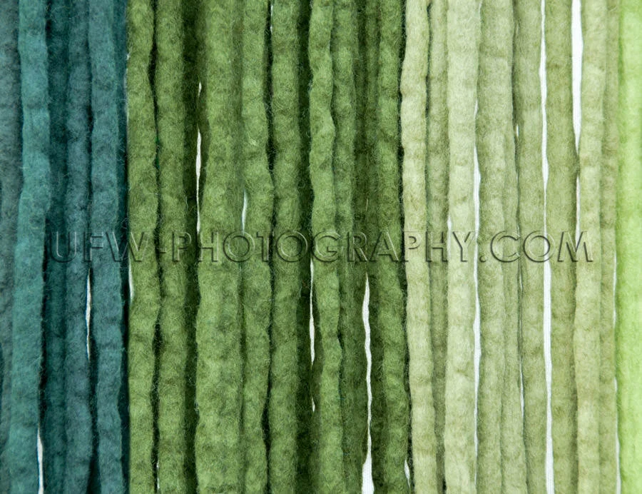 Felt ribbons blue green colored vertical strings background Stoc