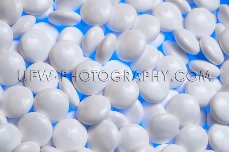 White pills macro illuminated blue background Stock Image