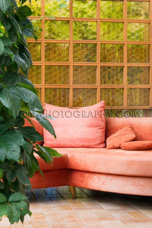 Patio cozy corner sofa orange plant tiled floor garden Stock Ima