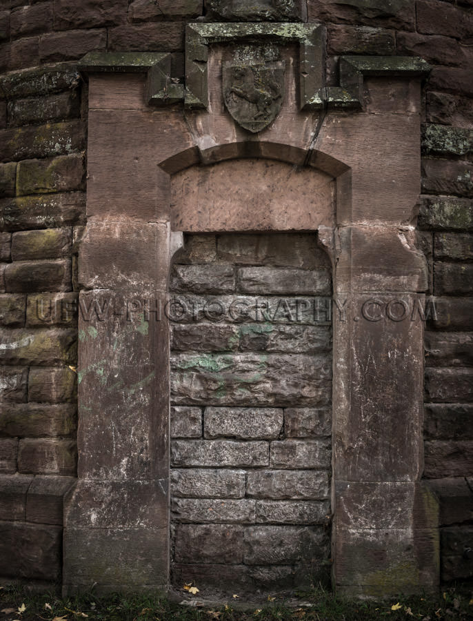 Sinister bricked-up portal old dark tower red sandstone Stock Im