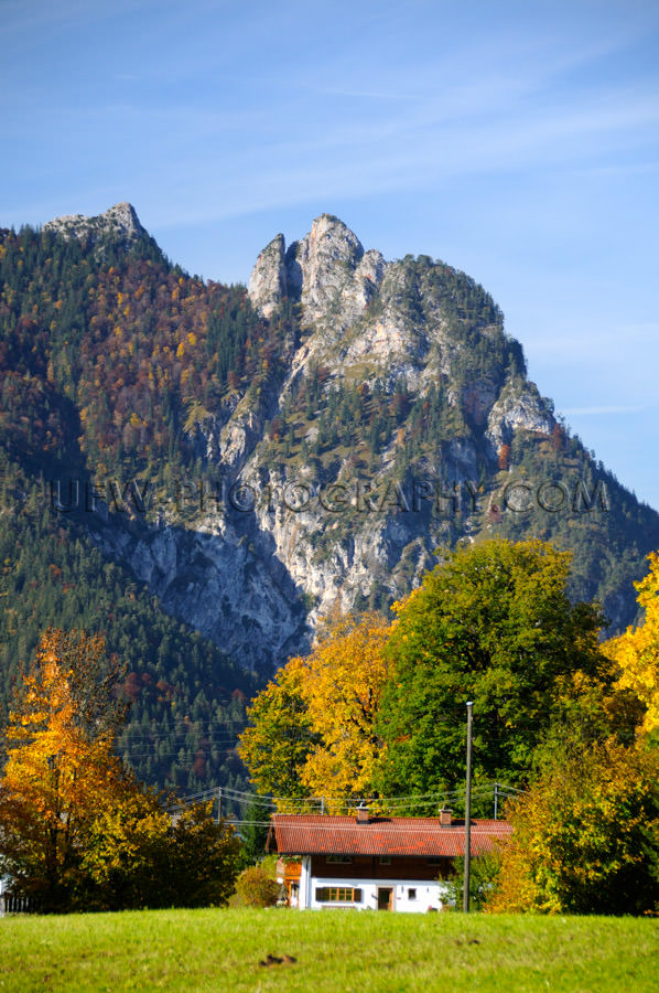 Idyllic farmhouse below witch mountain colorful fall trees Stock