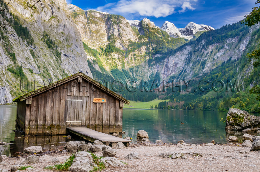 Mountain lake fishing hut surrounded high mountain-range Stock I