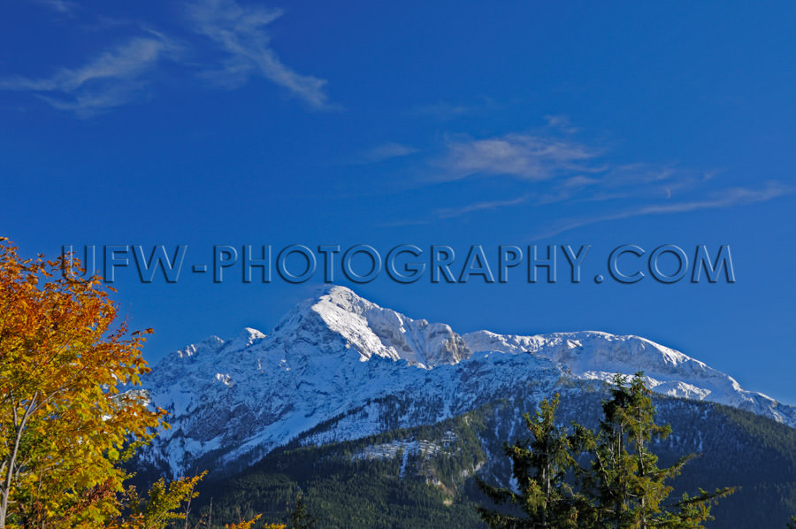 Mountain ridge with snowcapped peak against deep blue sky Stock 