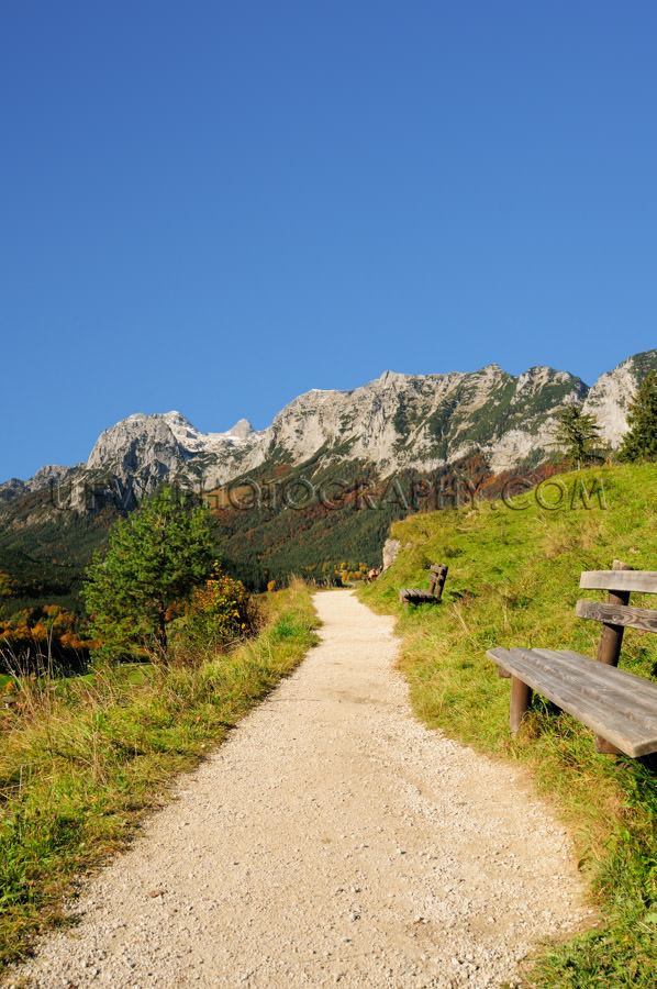 Sunny hiking trail in the mountains against deep blue sky Stock 