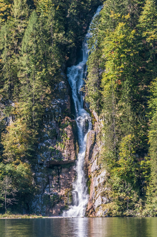 Waterfall steep cliff trees falling beautiful mountain lake Stoc