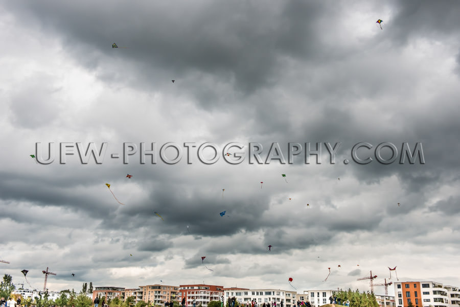 Many kites flying air kite-festival dark cloudy sky Stock Image