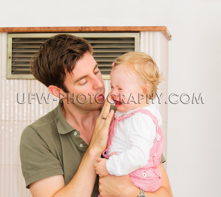 Crying girl toddler lovely young father caring one-year-old Stoc
