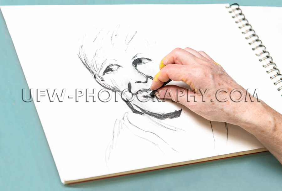 Human hand draws portrait charcoal pencil sketchbook Stock Image