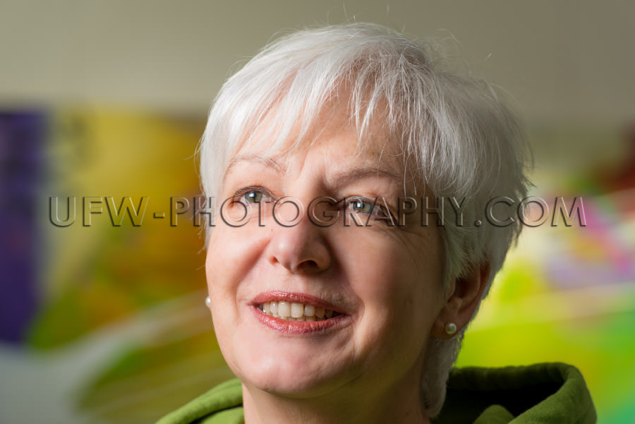 Portrait natural woman artist gray hair blurred background Stock