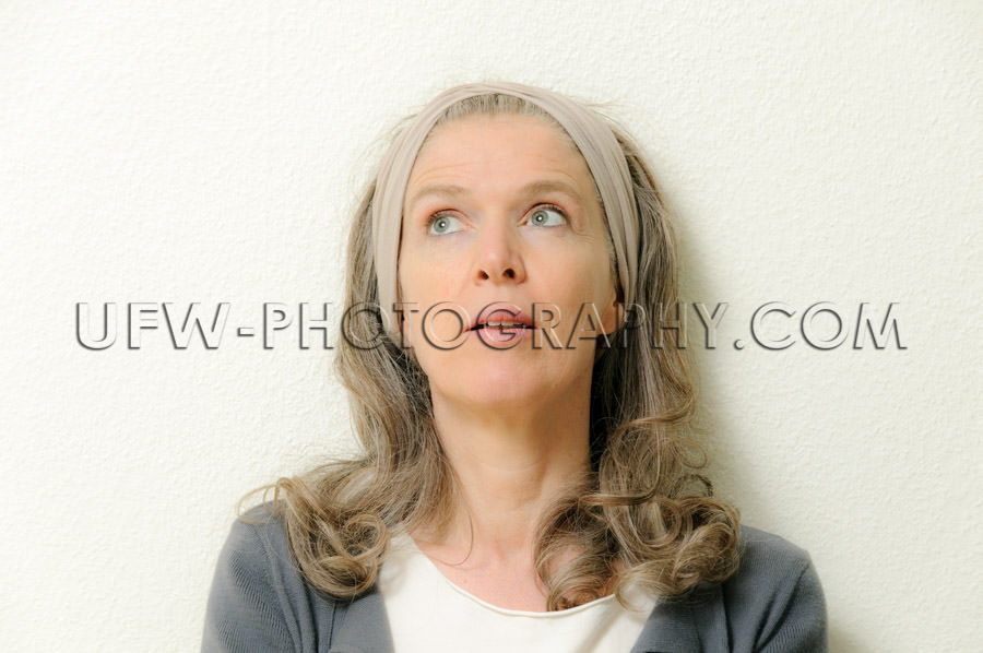 Portrait of a mature woman, looking up, pensive - Stock Image