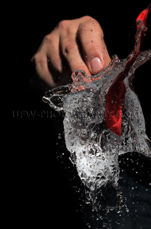 Water splash explodes hand black background balloon Stock Image