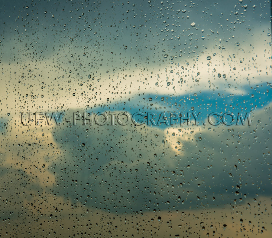 Raindrops window cloud sky blue patch rainy day Stock Image