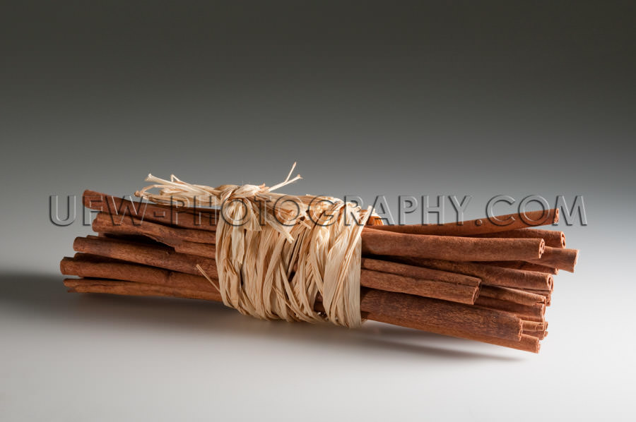 Bunch of spicy cinnamon sticks tied up straw ribbon Stock Image