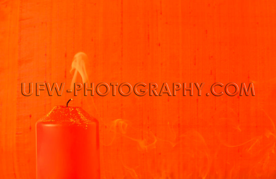 Extinguished light, red candle, golden glitter, smoke, textile b
