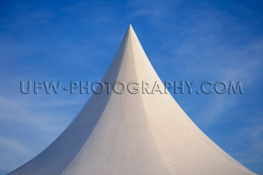 White peaked tent against deep blue sky Stock Image