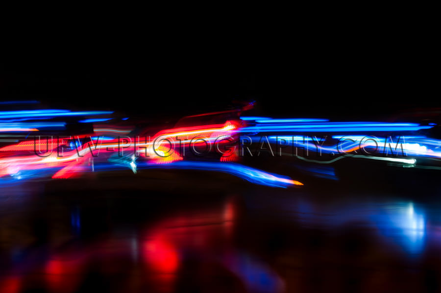 Abstract moving traffic lights red white blue motion blur black 