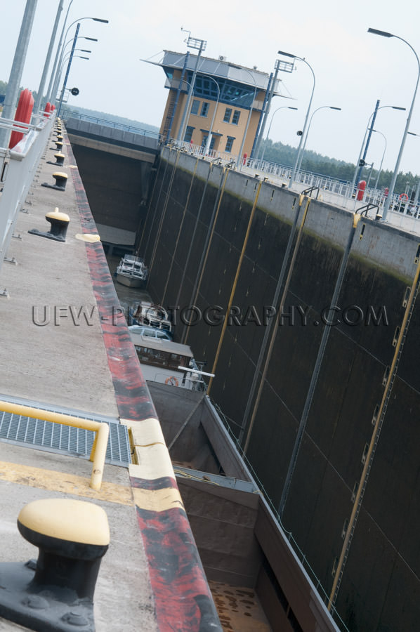 Deep river sluice with motorboats and cargo barge Stock Image