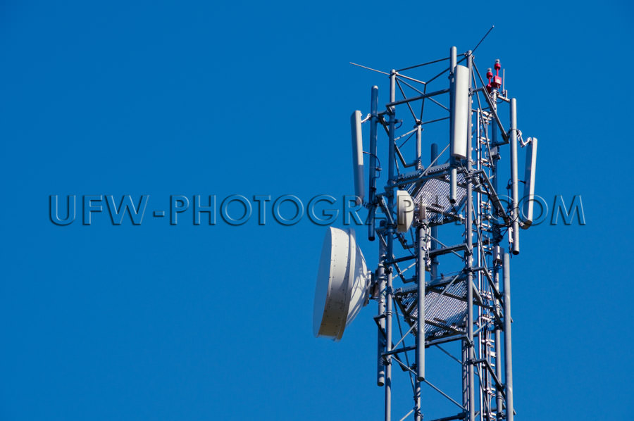 Mobile phone antenna close up against deep blue clear sky Stock 