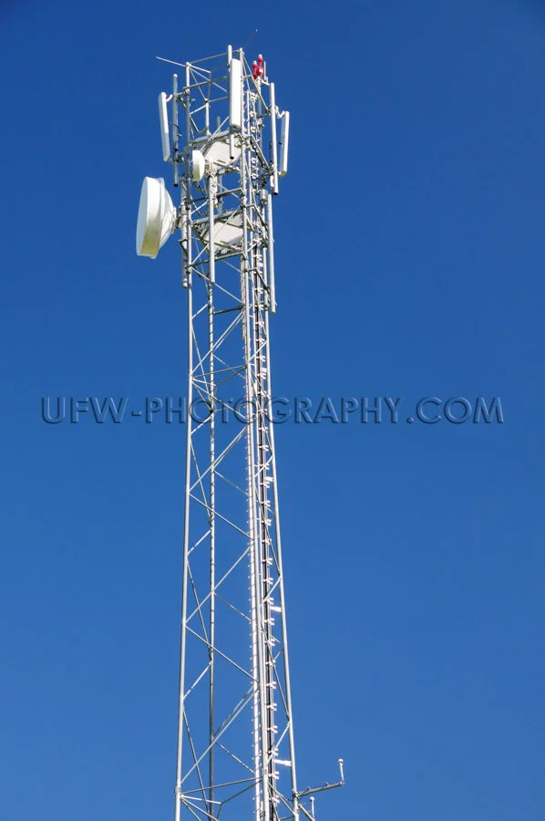 Mobile phone antenna transmitter dish deep blue clear sky Stock