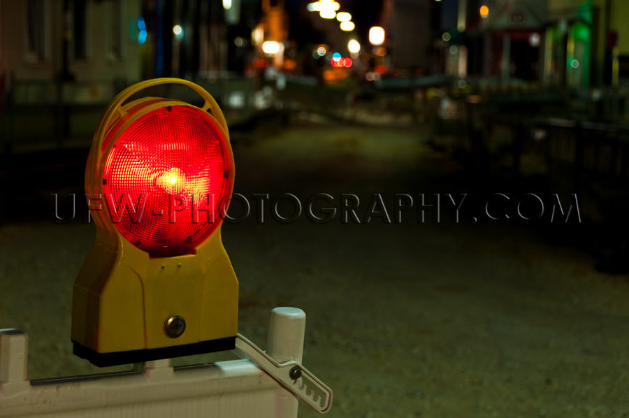 Red warning light illuminated road construction site night Stock