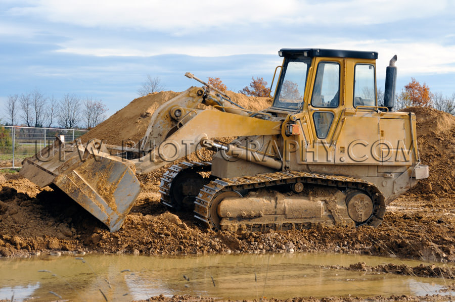 Track loader dirty bulldozer caterpillar tracks mud puddle Stock