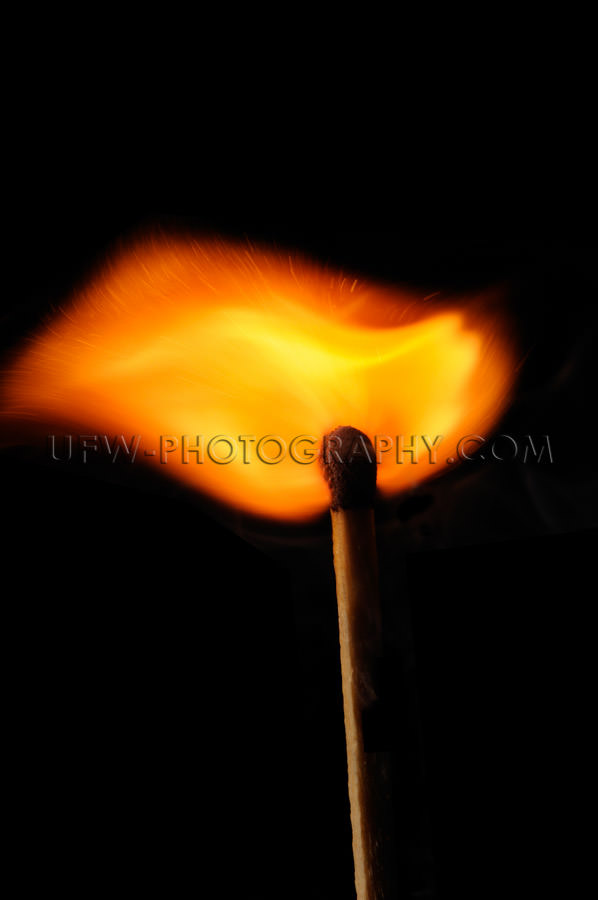 Burning matchstick emanates a beautifully shaped fire wave Stock