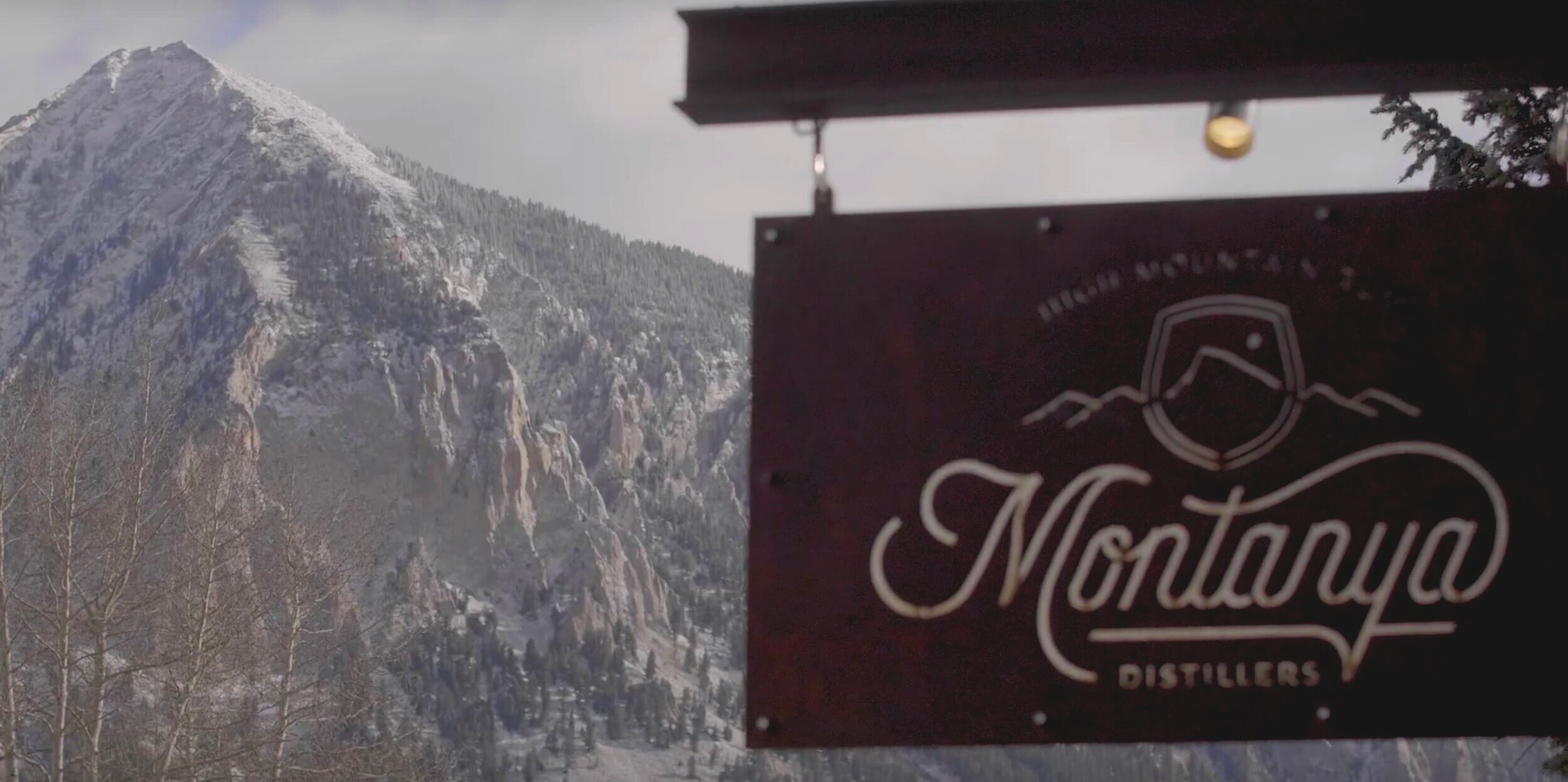 Montanya Distillers sign in front of Crested Butte Mountain Peak.