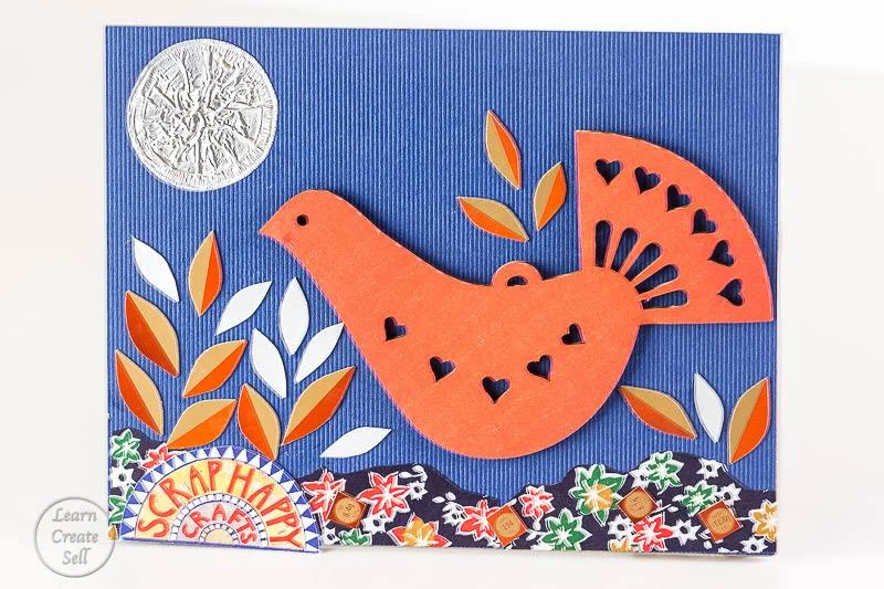 Handmade recycled laser cut Christmas bird card decoration. Orange and blue themed.