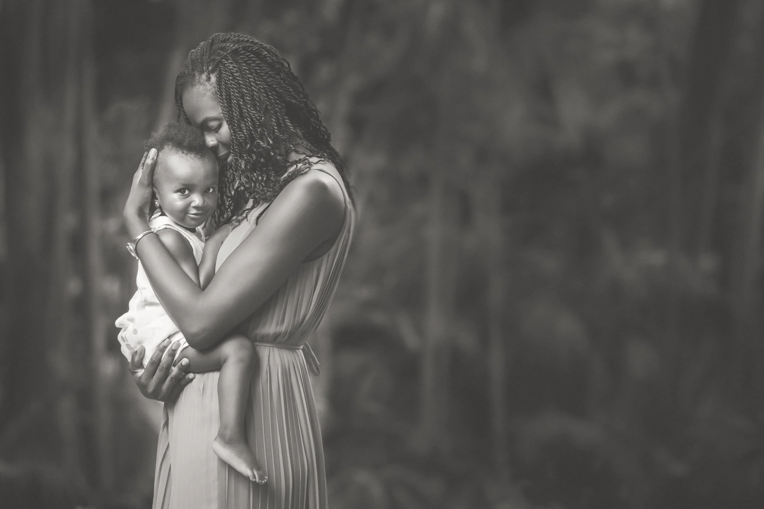 Smiling toddler embraced by her mother in Southlands Park in Bermuda