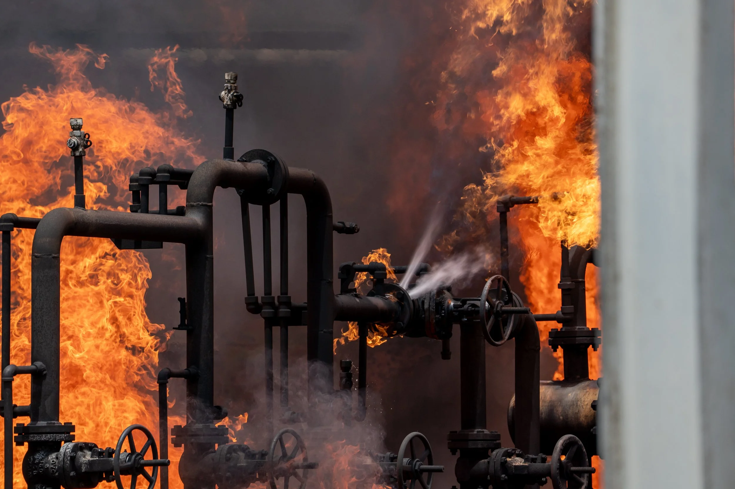 Industrial pipes and valves with flames and smoke coming from them