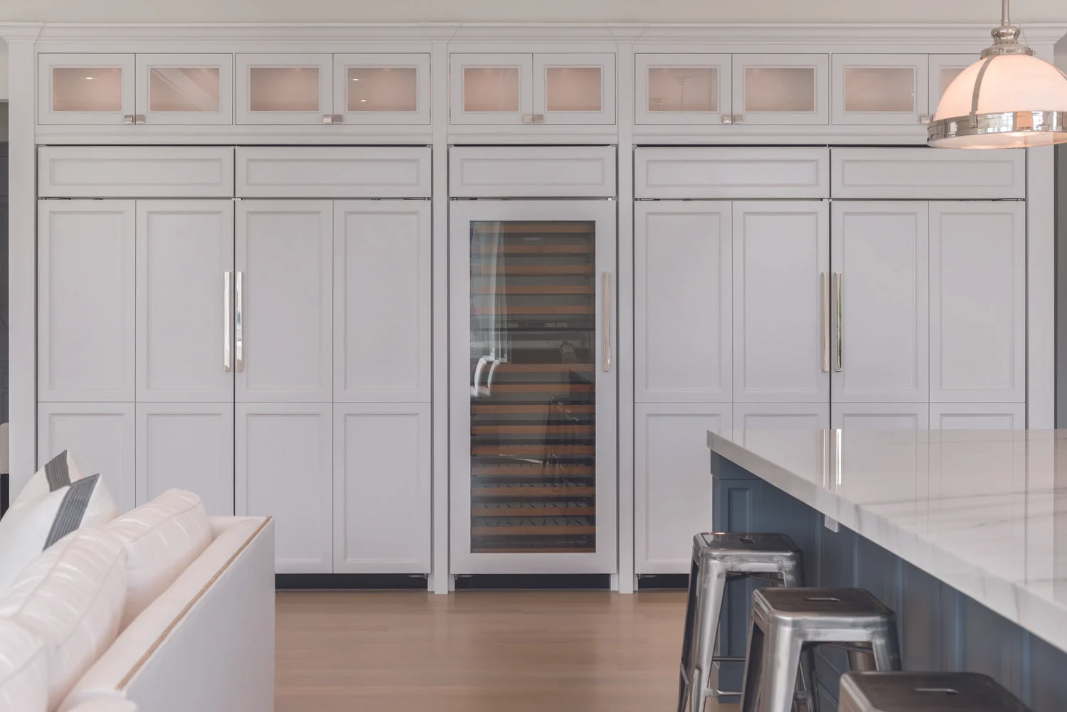 A wall of panel-ready fridges and freezers in a traditional white Hamptons style