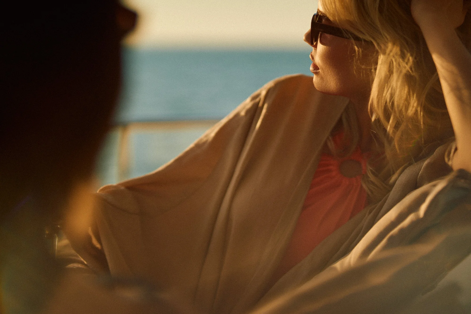 People sitting outdoors, woman with sunglasses, relaxed and enjoying the view.