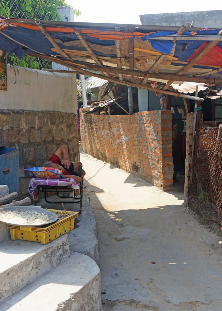 Sleeping man and sticky rice drying in the sun