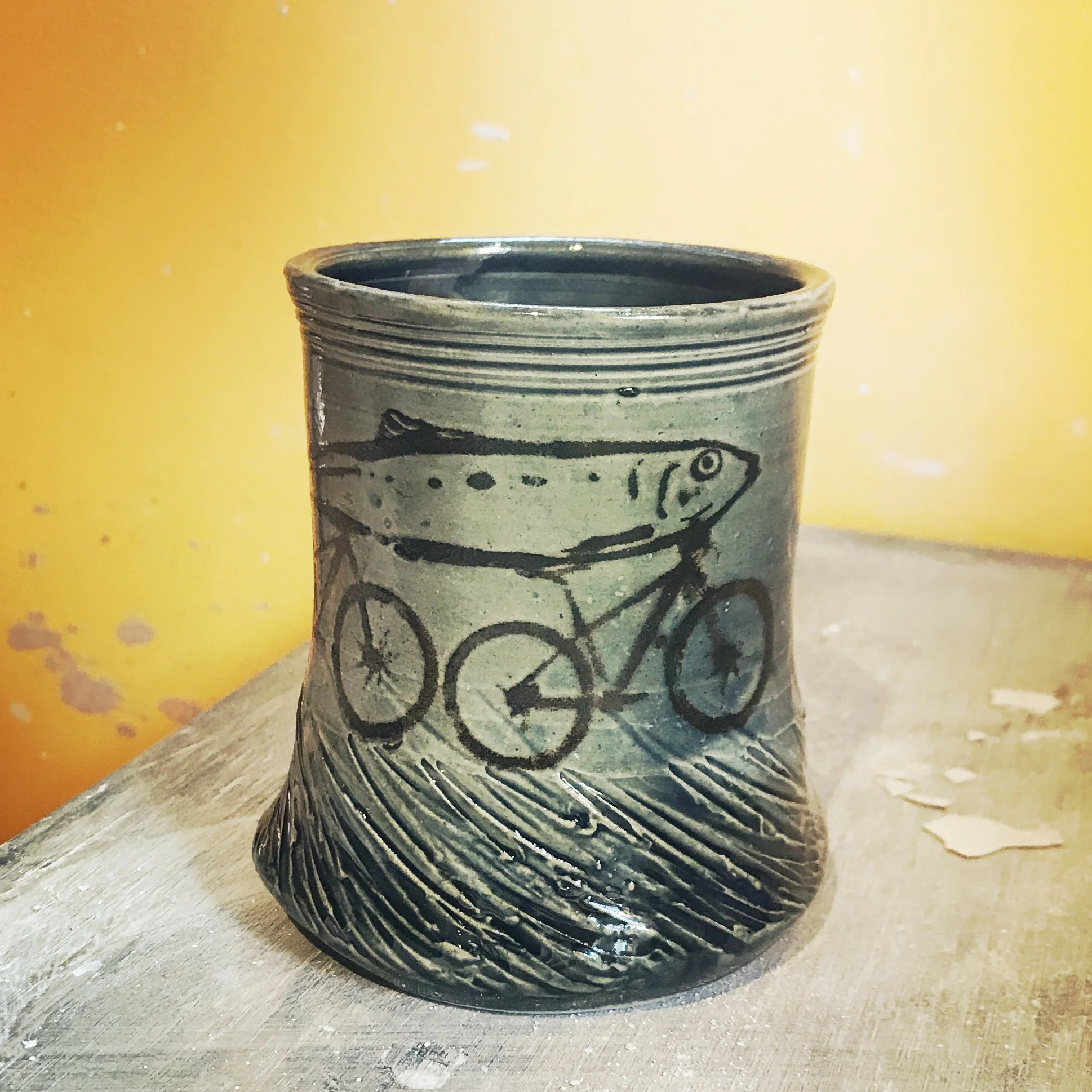 stoneware mug with unique fish on not one but two bicycles