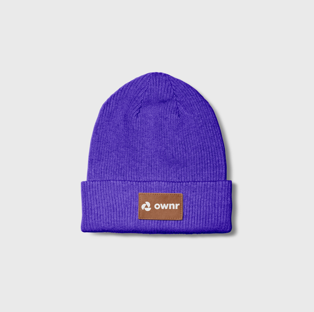 A purple knitted beanie hat with a brown patch label that says "ownr" on a light gray background.