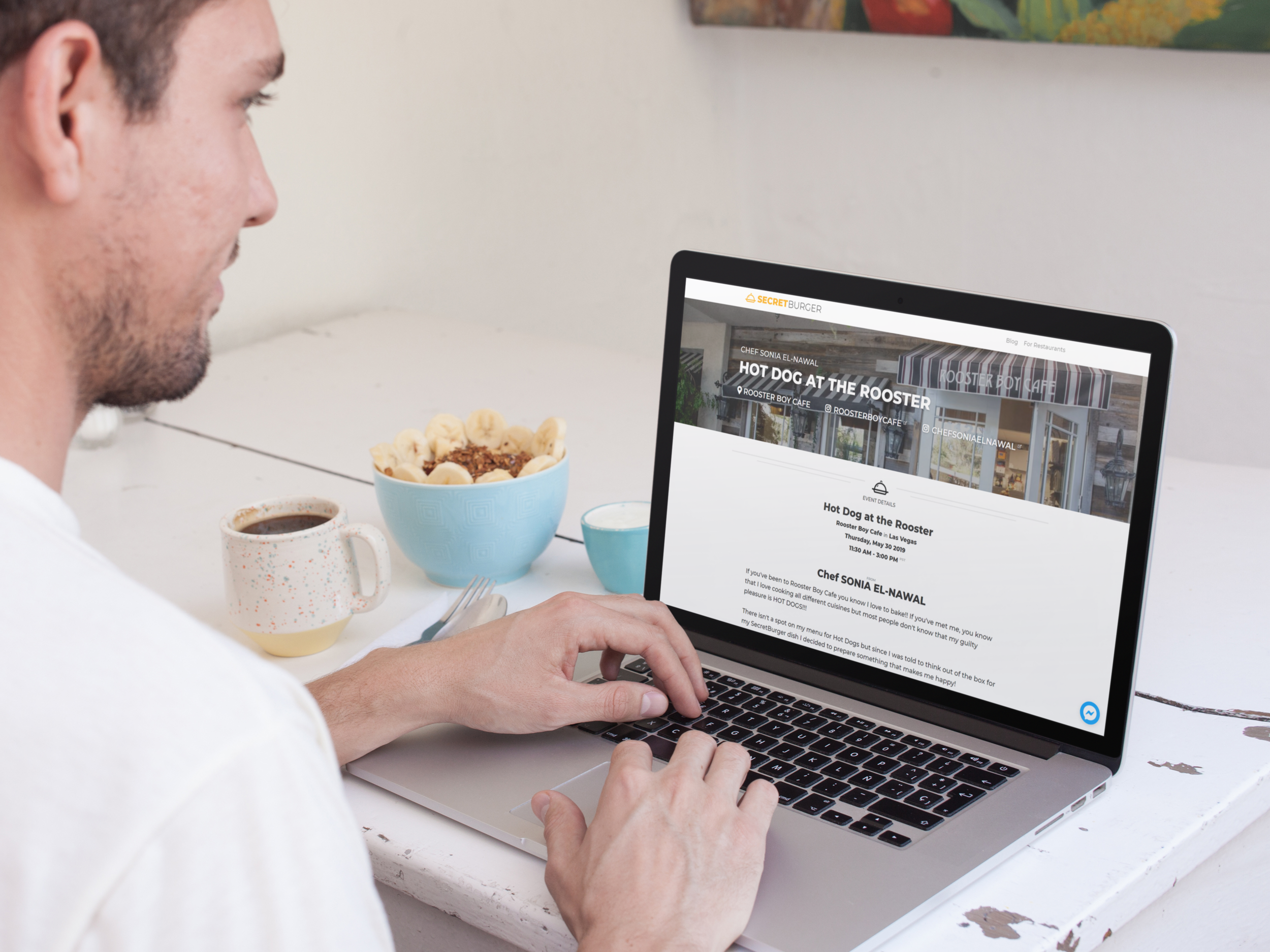 over-shoulder-template-of-a-young-man-using-his-macbook-in-a-white-table-while-at-a-restaurant-a14127.png