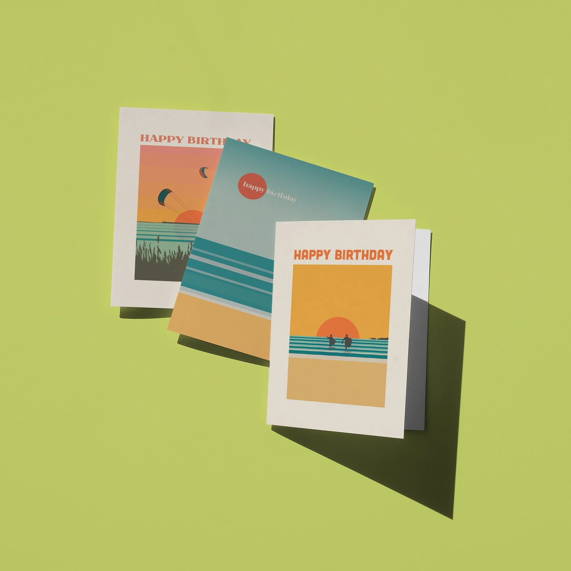 Three folded birthday cards on a lime green background with shadows.