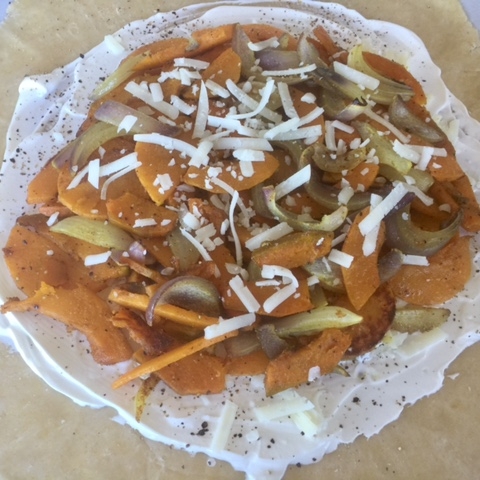 3. Spread sour cream leaving a 2-inch border. Top with cheese and veggies. 