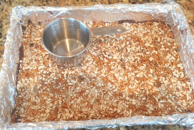 Use a measuring cup to firmly press the pretzel crumbs into the chocolate before and after baking. 