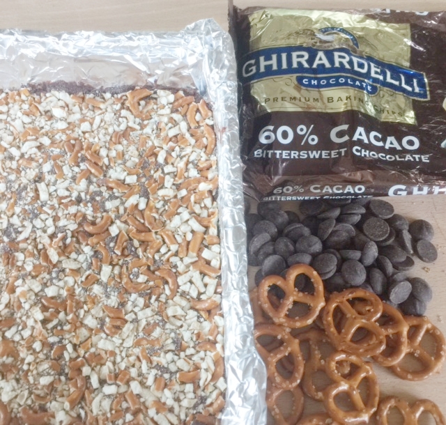 Ingredients for cookies and cookies layered in pan topped with crushed pretzels. Note the pretzels are various sizes. 