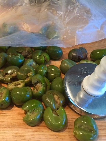 Removing the pit from the olives by lightly pounding them. I use a meat pounder.
