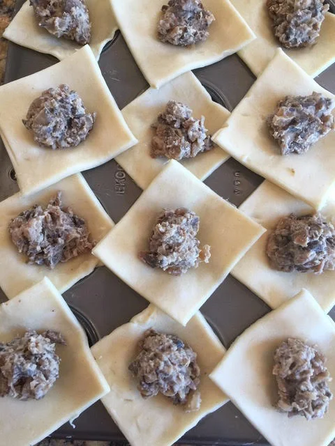 Layer each of the squares over a muffin tin and top with a teaspoon of filling. 