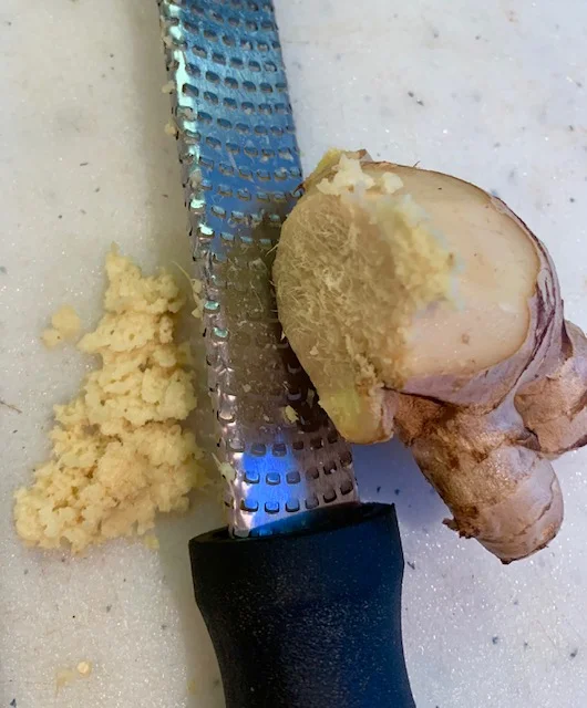 Grate ginger on a microplane, the small holes on a hand grater or in an electric coffee grinder.