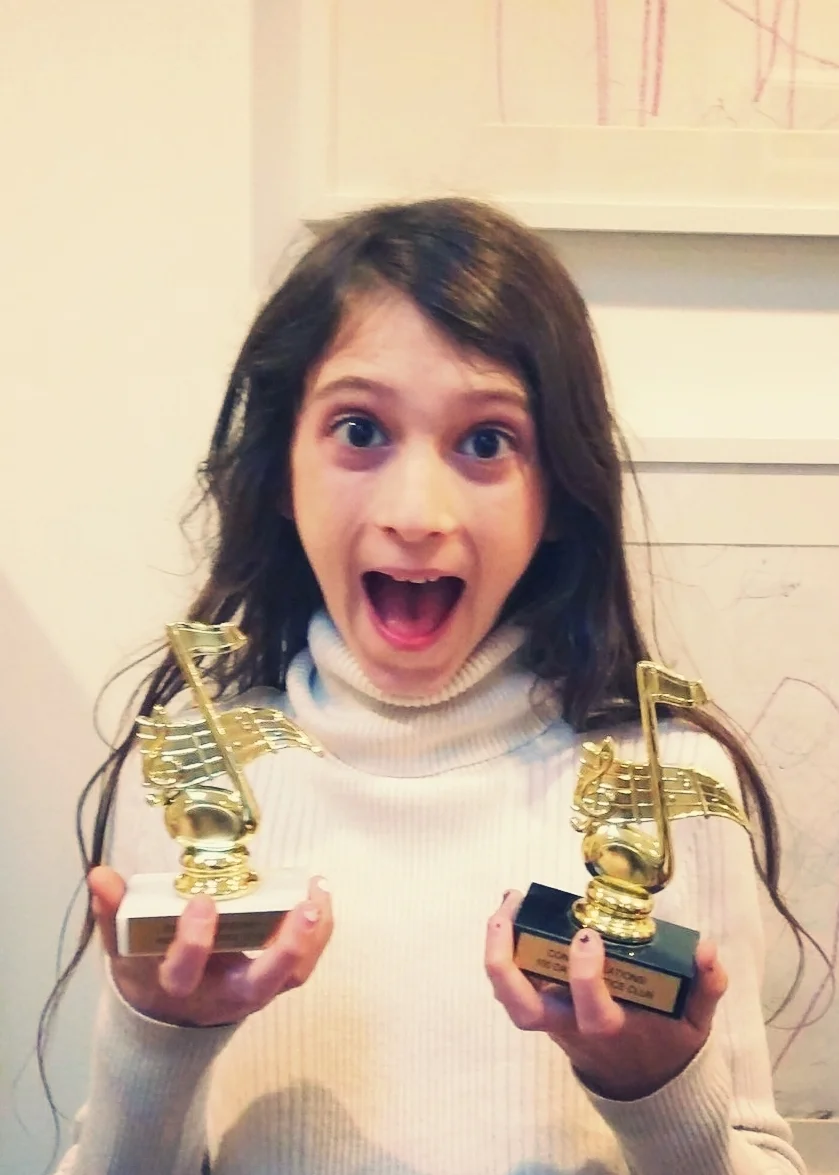 Student Holding Two Trophies