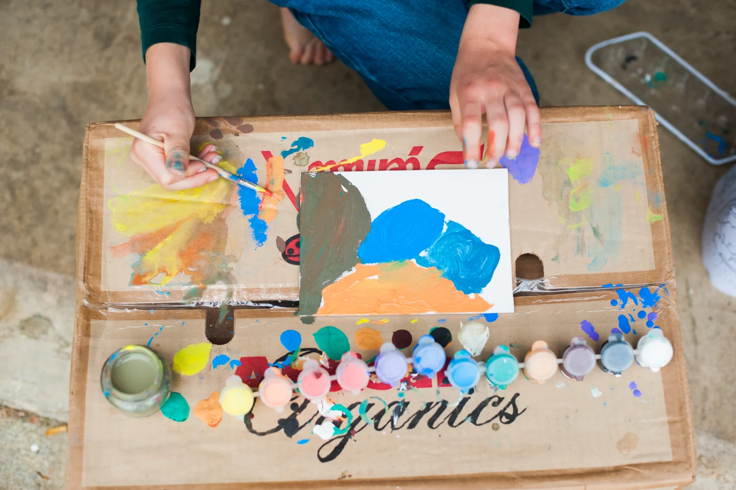 A young child painting on a canvas