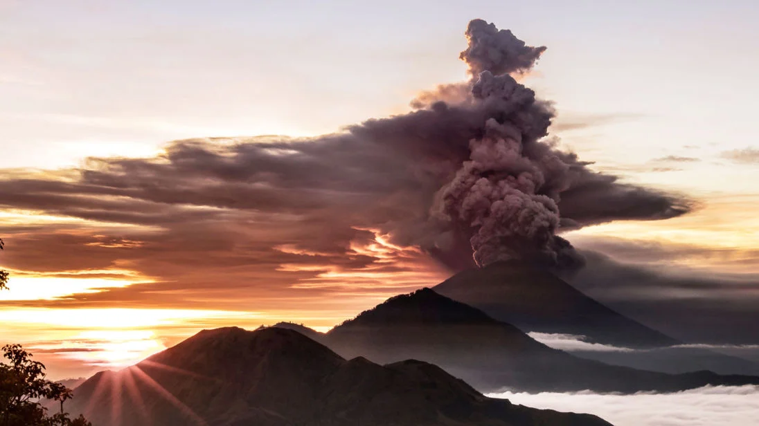 Ash and smoke pouring out of Mount Agung and high up into the atmosphere over the tropical island of Bali, Indonesia.. 