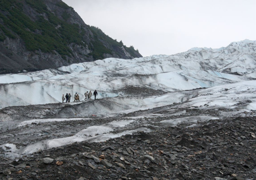 A group of visiting military members stand on Colony Glacier above the aircraft debris field actively being excavated during June 2017; (Photo courtesy Laurel Andrews/Alaska Dispatch News)